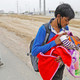 A migrant worker feeds his newborn baby as he walks on a highway on the outskirts of Delhi looking for a transport to return to his village.